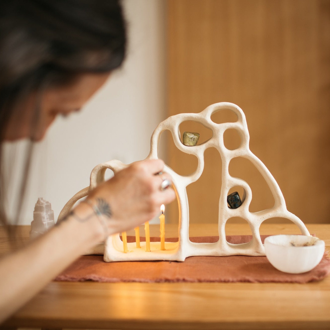 Anna Flowers lighting ceramic altar with candles